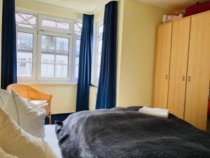 宾茨Villa Sanddorn的一间卧室配有蓝色窗帘、一张床和窗户