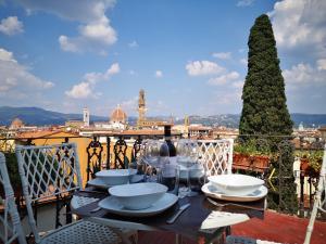 佛罗伦萨The View Of Sangiorgio的阳台上的桌子上摆放着盘子和酒杯