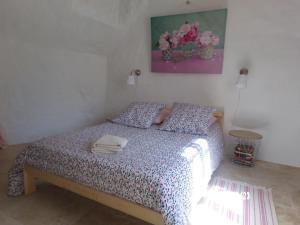 阿宰勒里多Le Troglo des Renaudières的一间卧室,卧室里配有一张床,上面有一堆毛巾