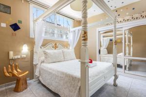 德尔锡伦西奥海岸Los MOXAICOS, TENERIFE的卧室配有白色的天蓬床和窗户。