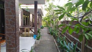 吉利特拉旺安库苏卡简易别墅民宿的建筑一侧有植物的狭窄小巷