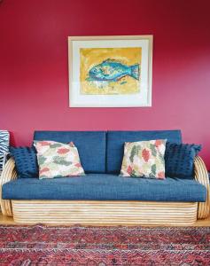 奥克兰Shelly Beach Studio, Waiheke Island的客厅配有带枕头的蓝色沙发