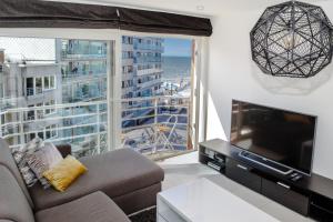 米德尔克尔克Lumina Suite Seaview & Garage的带沙发和大窗户的客厅