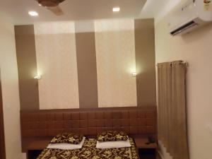 瓦拉纳西阿尔卡酒店的一间卧室设有两张床和大镜子