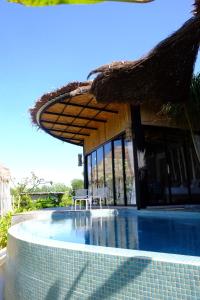 阁遥岛Awana Villa Resort Yaonoi - SHA Extra Plus的一个带稻草伞的游泳池的度假酒店