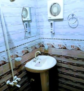 卡拉奇Gulshan Palace Near Millennium Mall的浴室配有白色水槽和风扇
