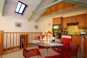 纽基Granary at Trewerry Cottages - Away from it all, close to everywhere的一间厨房,里面配有桌子和红色椅子
