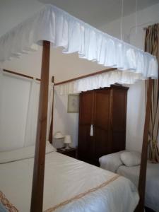 阿尔玛格鲁Casa De Comedias的卧室配有带白色床单的天蓬床