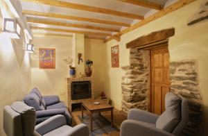 Murias de ParedesCasa Rural El Llao Y Los Fresnos - El Urogallo的客厅配有2把蓝色椅子和壁炉