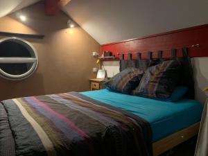 圣米舍德谢洛loft sur les montagnes的一间卧室配有一张红色床头板的床