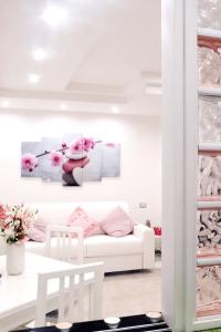 萨莱诺Anchor and Rose的白色的客厅配有白色的沙发和粉红色的鲜花
