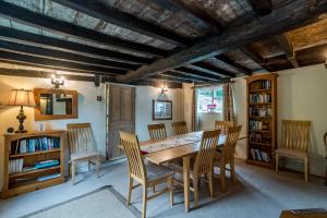 MoulsoeYew Tree Cottage的一间带木桌和椅子的用餐室