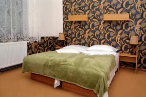 赫林斯科霍拉卡膳食公寓的一间卧室配有一张带绿床罩的床