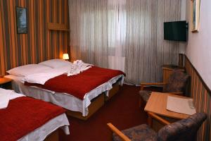 赫林斯科霍拉卡膳食公寓的酒店客房带两张床和一张桌子以及椅子。