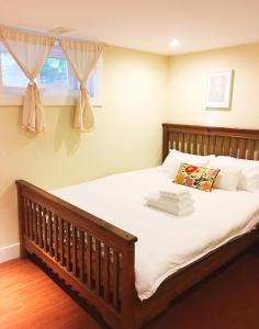温哥华邓巴之家民宿的一间卧室配有一张带白色床单的床和一扇窗户。