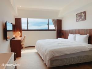 台东行云会馆的一间卧室配有一张床、一张书桌和窗户。