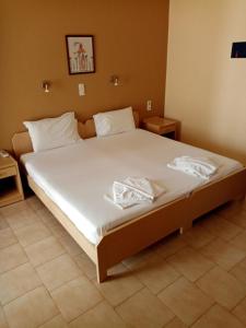 普拉塔尼亚斯约翰公寓的一间卧室配有一张带白色床单的大床