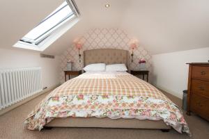 惠特比Granny's Attic at Cliff House Farm Holiday Cottages,的一间卧室配有一张带花卉床罩的床