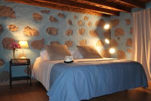 蓬塔利亚纳Casa Fita en El Cubo de La Galga的一间卧室配有一张带岩石墙的床
