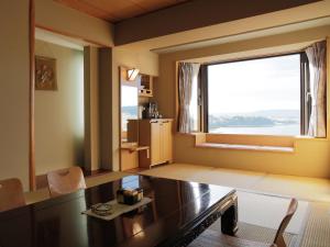 阿寒湖畔阿寒之森鹤雅休闲度假酒店花悠香的客厅设有桌子和大窗户
