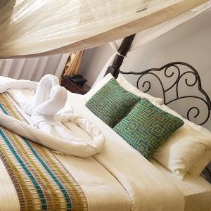 内罗毕玛格丽塔之家旅馆的一张带毛巾和枕头的床