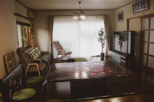 本宫Guesthouse Yui的客厅配有桌子和沙发
