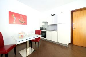 巴里Casa Turati的一间带桌子和红色椅子的小厨房