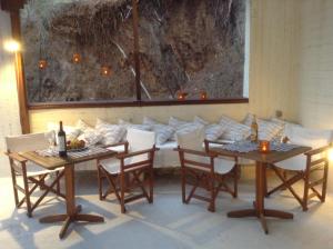 瓦西里亚斯曼丹尼公寓式酒店的一间带两张桌子和一张沙发的用餐室