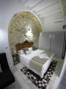 锡拉库扎Ammira的一间卧室设有一张床和石墙
