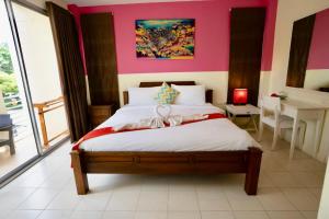 卡塔海滩OK Phuket的一间卧室配有一张粉红色墙壁的床