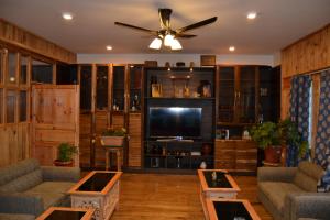 帕罗Yangkey Villa的客厅配有吊扇和电视。