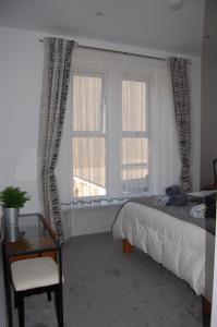 滨海韦斯顿Central Living Apartment的一间卧室配有一张床和一个带椅子的窗户