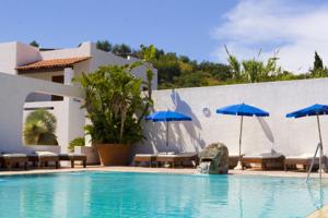 伊斯基亚米拉丽莎别墅酒店的一个带遮阳伞和椅子的游泳池以及一座建筑