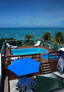 马拉戈日珊瑚之岸旅馆的阳台设有2个游泳池和椅子,享有海景。