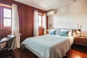 波尔图Charming Bonfim Penthouse的一间卧室配有一张带蓝色枕头的床