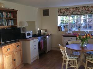 BenendenFreshwater Barn的厨房配有桌子、微波炉和桌椅