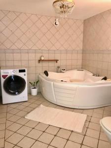 耶夫勒Magasin 4的带浴缸和洗衣机的浴室。