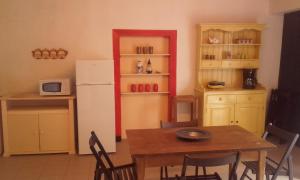 Le FleixLe Grenouillet的厨房配有桌子和白色冰箱。