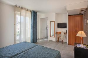普罗普里亚诺勒纳普图酒店及水疗中心的一间卧室配有一张床、一张桌子和一台电视