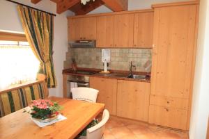 科姆梅扎杜拉Maso Margherita的厨房配有木制橱柜和木桌。
