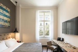 布拉格Quentin Prague Hotel的一间卧室配有一张床、一张书桌和一个窗户。