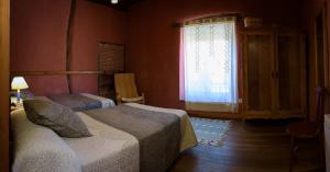 TraguntiaCasa Rural Caenia Grupos的一间卧室设有两张床和窗户。