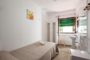 伊维萨镇拉斯涅韦斯旅馆的白色卧室设有床铺和水槽