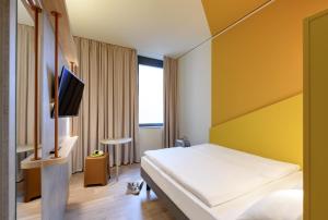 不莱梅ibis budget Bremen City Center的一间酒店客房,配有一张床和一台电视