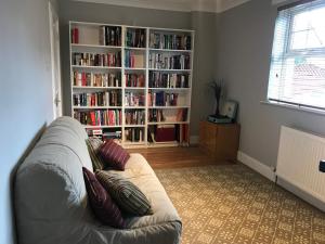 阿普海尔The Neuk的客厅配有沙发和带书籍的书架