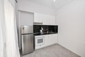 拉里萨Modern, comfortable apartment, in the heart of the city的厨房配有白色橱柜和不锈钢冰箱