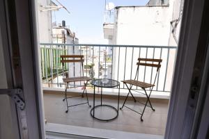 拉里萨Modern, comfortable apartment, in the heart of the city的阳台配有2把椅子和1张桌子