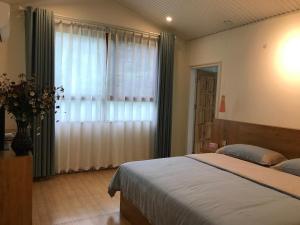 恩施恩施大峡谷春伦农家乐的一间卧室设有一张大床和一个窗户。