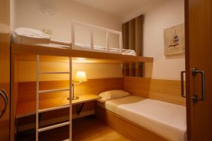 巴塞罗那韦洛公寓的小房间设有两张双层床和一盏灯。