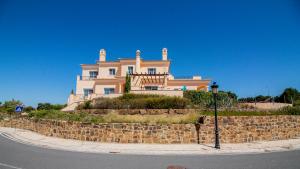 马林堡Villas @ Quinta do Vale Golfe的石墙顶上的大房子